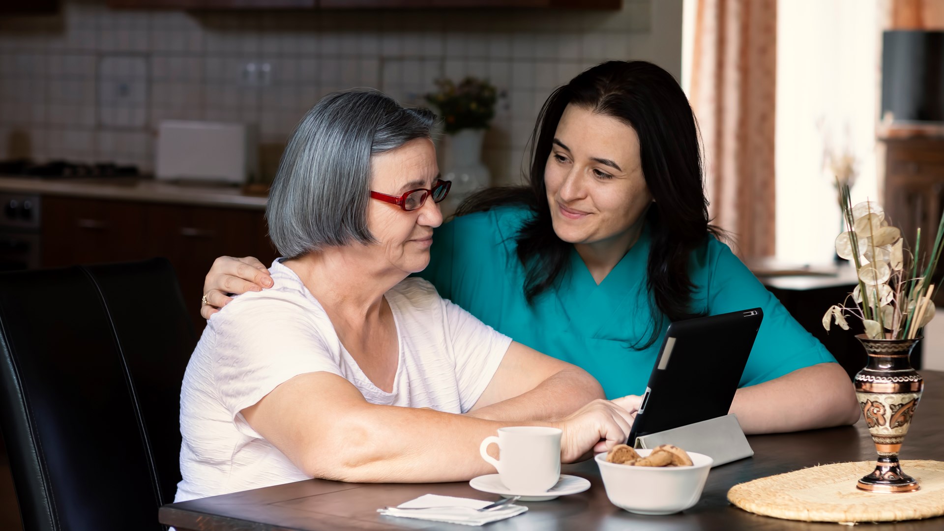 Mp38119532 Caring Nurse Showing A Digital Tablet To An Elderly Woman Mindre