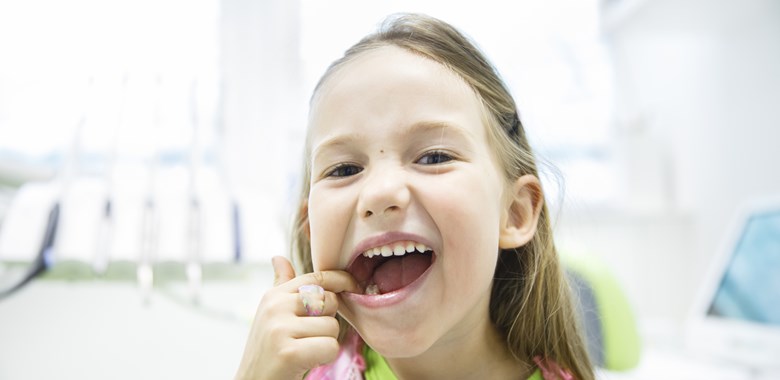 12859387 Girl Showing Her Healthy Milk Teeth At Dental Office