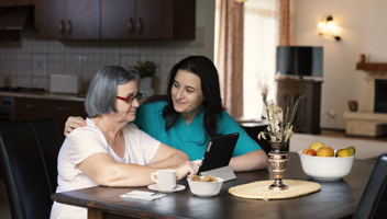 Mp38119532 Caring Nurse Showing A Digital Tablet To An Elderly Woman (1)